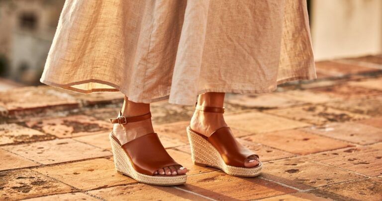 Robe longue en lin écru portée avec des espadrilles compensées en cuir cognac sur une terrasse méditerranéenne